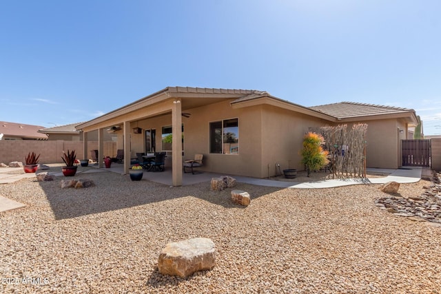 back of property featuring ceiling fan, a patio area, fence, and stucco siding