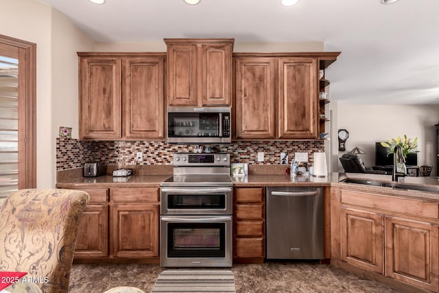 kitchen with tasteful backsplash, brown cabinets, appliances with stainless steel finishes, and a sink