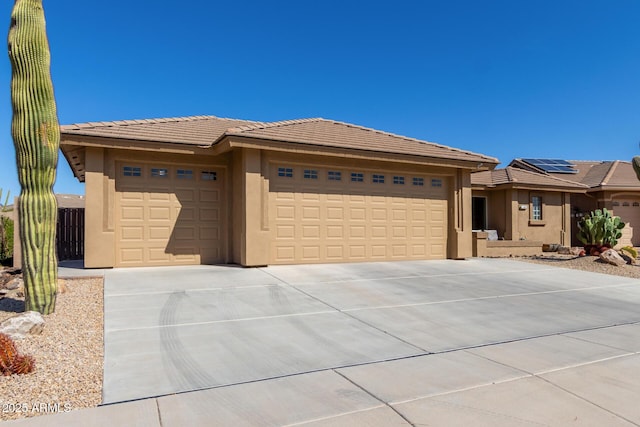 view of front of house featuring a tiled roof, stucco siding, driveway, and a garage