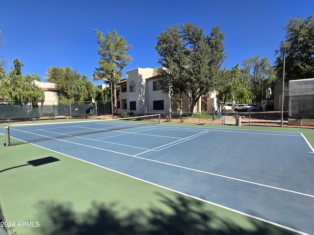 view of tennis court featuring fence and community basketball court