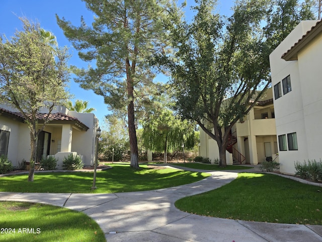 view of property's community featuring stairway and a lawn