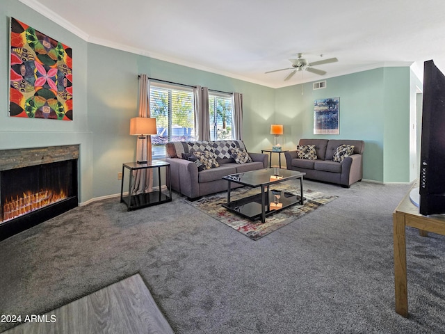 carpeted living room with crown molding, a ceiling fan, visible vents, and a lit fireplace
