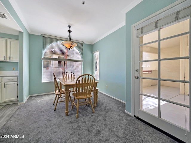 dining area with crown molding, baseboards, visible vents, and dark carpet