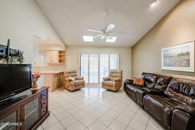 living room featuring light tile patterned floors, a textured ceiling, lofted ceiling with skylight, and ceiling fan