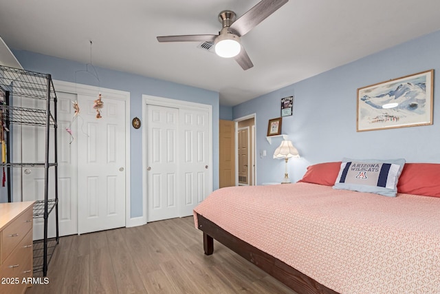 6532 E Aster Dr, Scottsdale, AZ 85254 - bedroom featuring two closets, wood finished floors, a ceiling fan, and baseboards