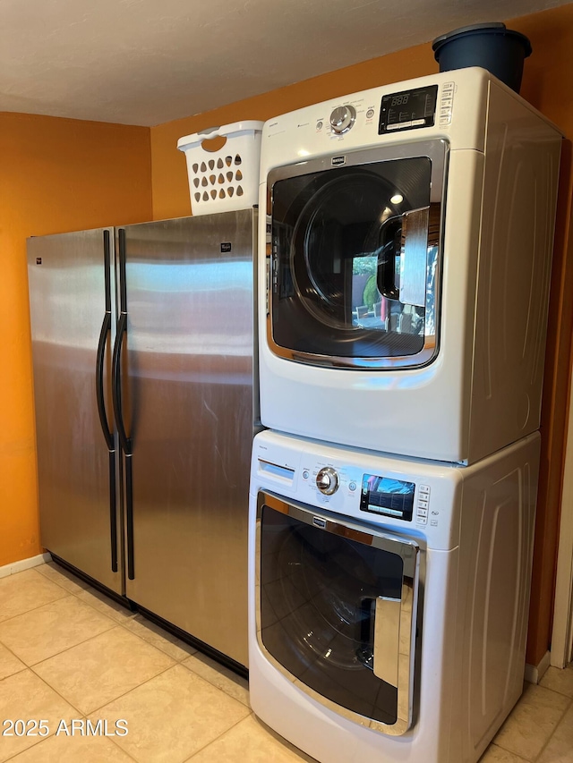 6532 E Aster Dr, Scottsdale, AZ 85254 - laundry area featuring stacked washing machine and dryer, light tile patterned flooring, and baseboards