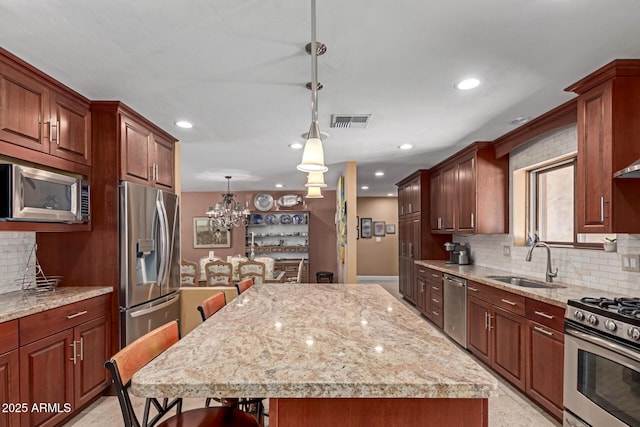 6532 E Aster Dr, Scottsdale, AZ 85254 - kitchen with appliances with stainless steel finishes, a sink, backsplash, a center island, and recessed lighting