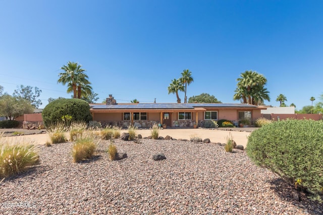 6532 E Aster Dr, Scottsdale, AZ 85254 - back of house featuring covered porch, solar panels, a chimney, and stucco siding