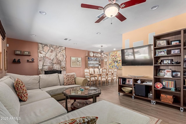 6532 E Aster Dr, Scottsdale, AZ 85254 - living area with a ceiling fan, wood finished floors, a chandelier, recessed lighting, and a stone fireplace