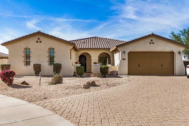 mediterranean / spanish home featuring a garage