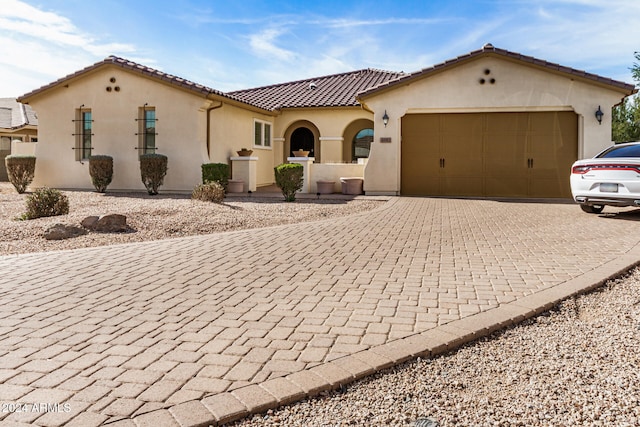 mediterranean / spanish-style home with a garage