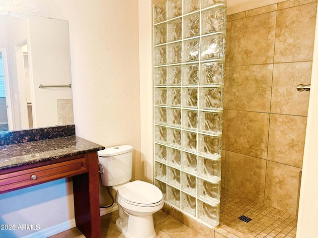 bathroom with vanity, tiled shower, tile patterned floors, and toilet