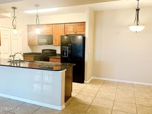 kitchen featuring sink, black appliances, hanging light fixtures, and dark stone counters