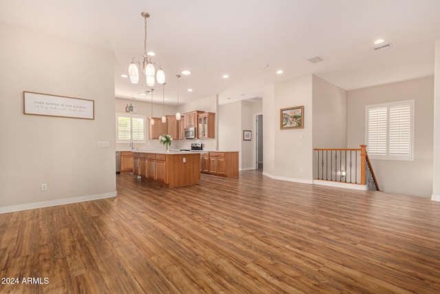 kitchen featuring dark hardwood / wood-style flooring, a center island, pendant lighting, and a notable chandelier