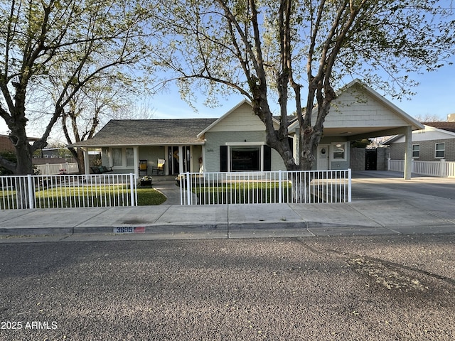 view of front facade featuring covered porch, an attached carport, driveway, and a fenced front yard