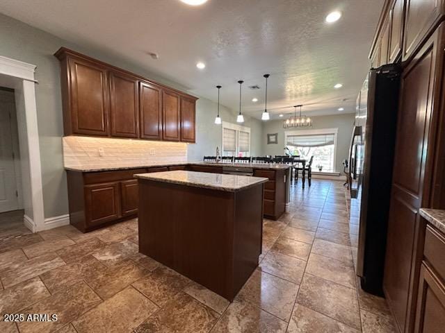 kitchen featuring pendant lighting, a peninsula, a center island, decorative backsplash, and recessed lighting