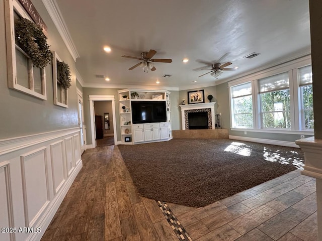 unfurnished living room featuring crown molding, a tile fireplace, a ceiling fan, dark wood-style floors, and visible vents