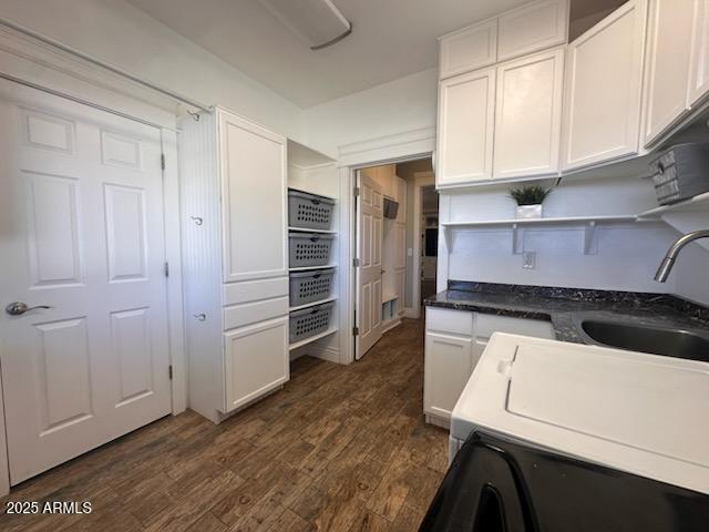 kitchen featuring a sink, open shelves, dark countertops, white cabinets, and dark wood-type flooring