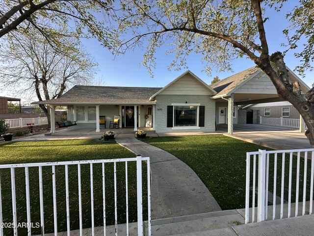 view of front of house featuring driveway, a fenced front yard, a front lawn, covered porch, and an attached carport