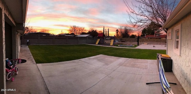 view of yard with a fenced backyard, a patio area, and a playground