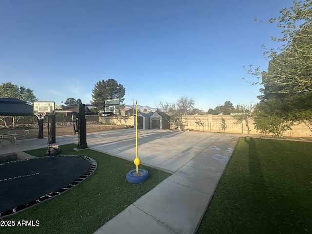 exterior space featuring an outbuilding, fence, and community basketball court