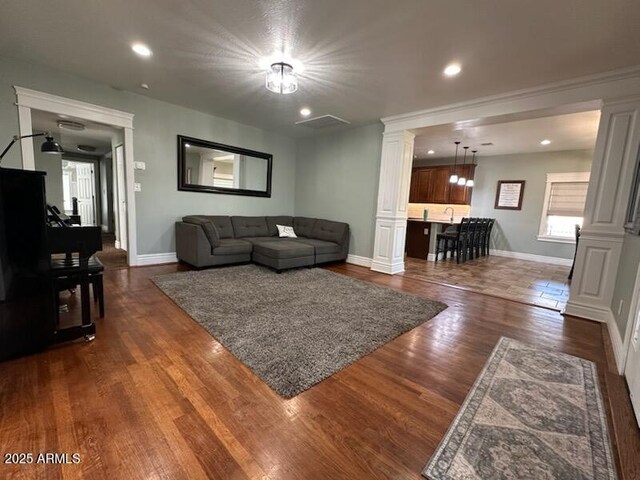 living room with baseboards, recessed lighting, decorative columns, and dark wood finished floors