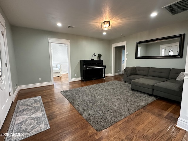 living area featuring dark wood-style flooring, recessed lighting, and visible vents