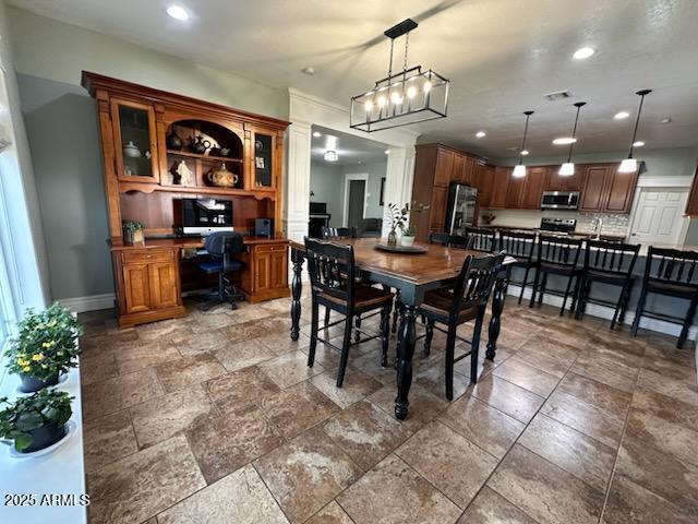 dining space featuring stone finish floor, baseboards, visible vents, built in desk, and recessed lighting