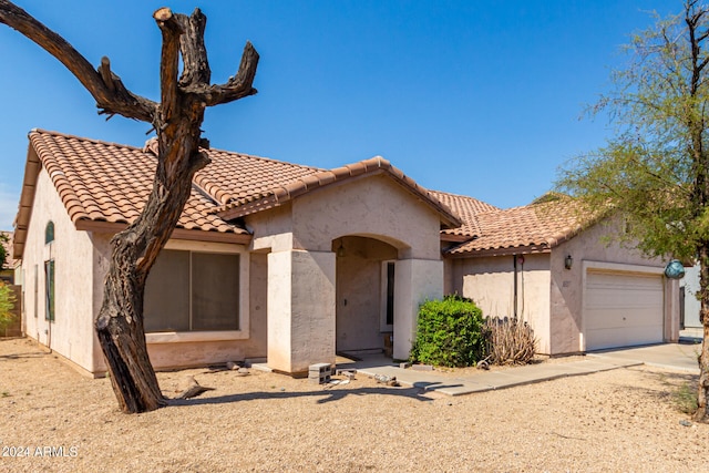 mediterranean / spanish-style home with a garage