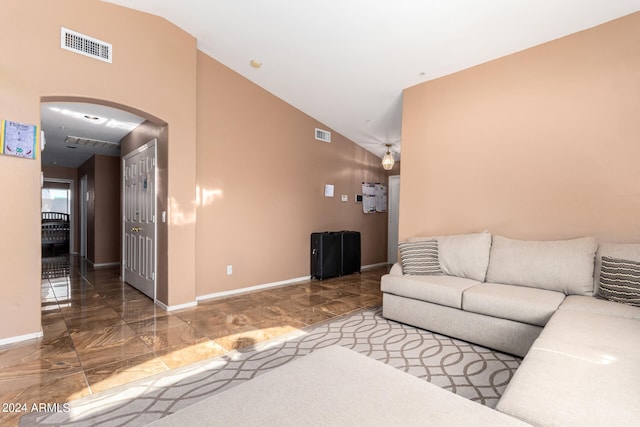 living room with tile patterned flooring and vaulted ceiling