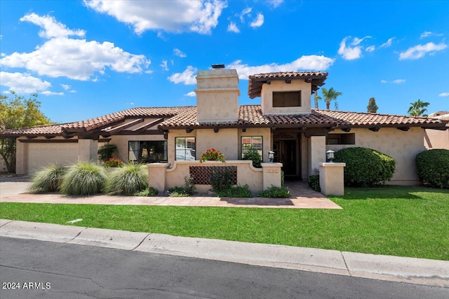 mediterranean / spanish-style home with a front lawn and a garage