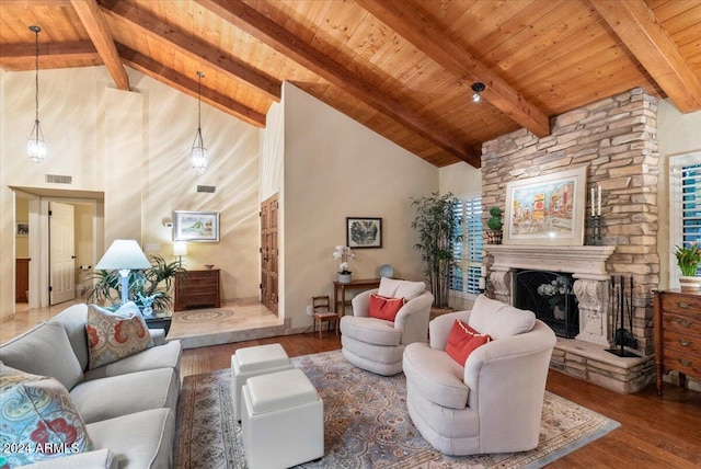 living room with a stone fireplace, beam ceiling, hardwood / wood-style floors, and high vaulted ceiling