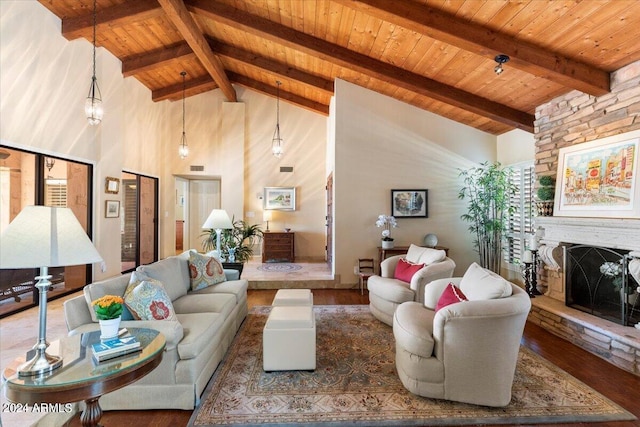 living room featuring beam ceiling, high vaulted ceiling, hardwood / wood-style floors, a stone fireplace, and wooden ceiling