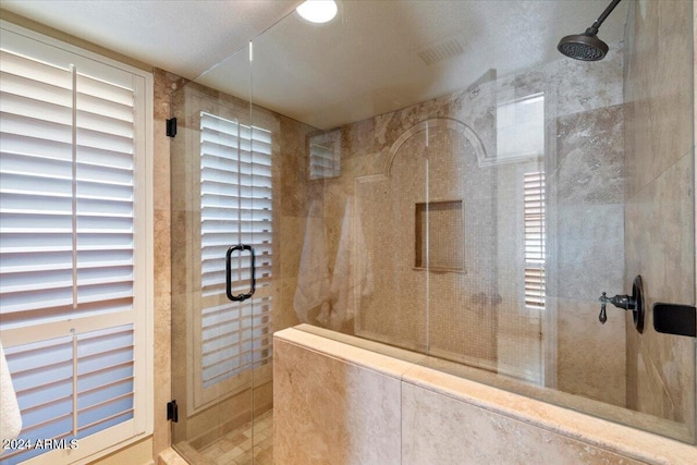 bathroom with a textured ceiling and walk in shower