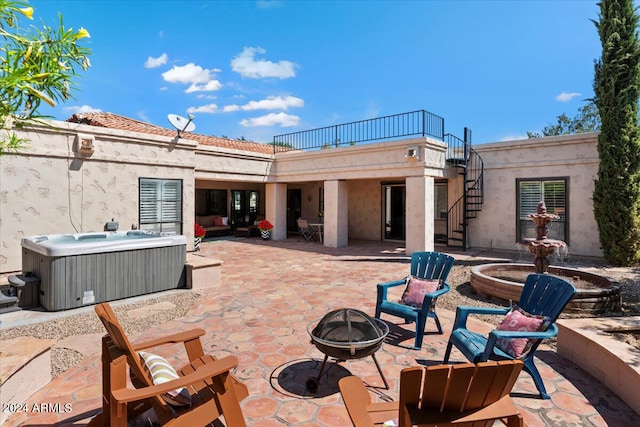 view of patio featuring a hot tub and an outdoor fire pit