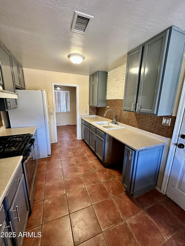 3211 W Campbell Ave, Phoenix, AZ 85017 - kitchen with gas range, decorative backsplash, light countertops, dark tile patterned flooring, and a textured ceiling