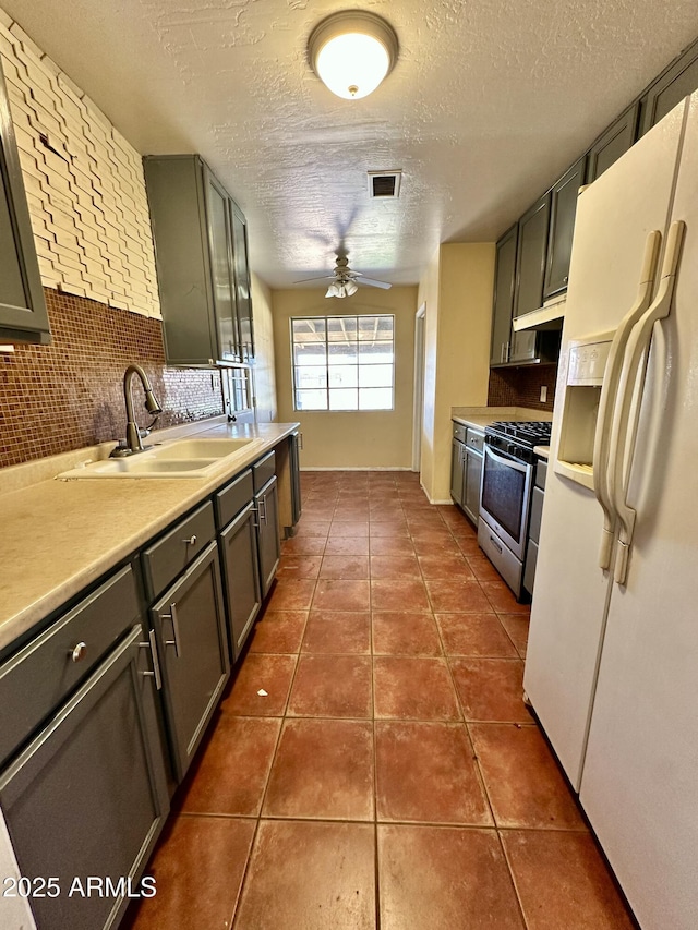 3211 W Campbell Ave, Phoenix, AZ 85017 - kitchen with white fridge with ice dispenser, stainless steel range with gas stovetop, under cabinet range hood, ceiling fan, and backsplash