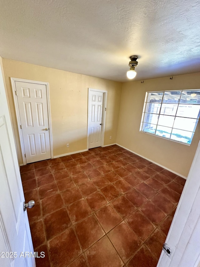 3211 W Campbell Ave, Phoenix, AZ 85017 - empty room featuring a textured ceiling and dark tile patterned flooring