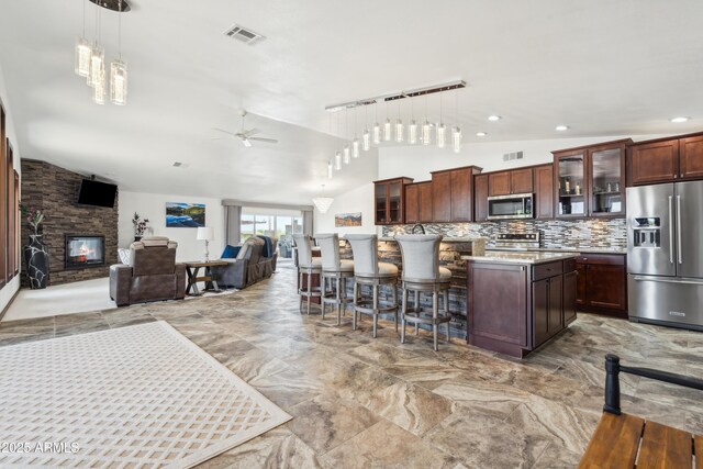 920 N 104th St, Mesa, AZ 85207 - kitchen featuring stainless steel appliances, vaulted ceiling, ceiling fan, light countertops, and decorative backsplash