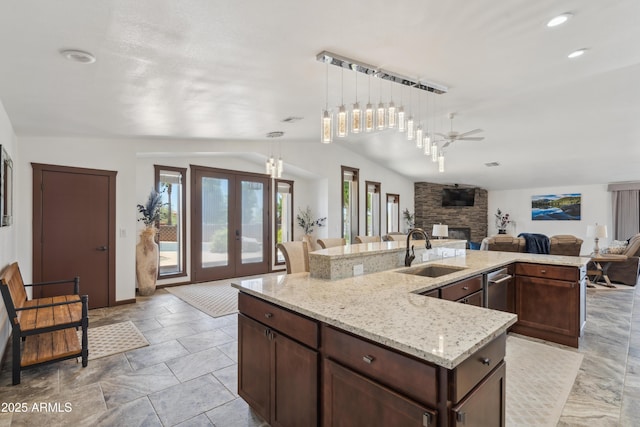 920 N 104th St, Mesa, AZ 85207 - kitchen featuring a sink, lofted ceiling, a center island with sink, a fireplace, and open floor plan