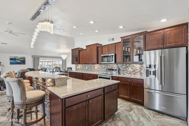 920 N 104th St, Mesa, AZ 85207 - kitchen featuring stainless steel appliances, vaulted ceiling, ceiling fan, tasteful backsplash, and open floor plan