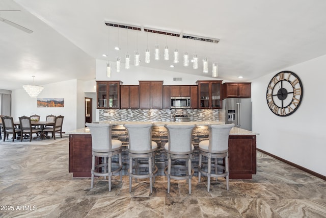 920 N 104th St, Mesa, AZ 85207 - kitchen featuring appliances with stainless steel finishes, decorative backsplash, vaulted ceiling, a spacious island, and decorative light fixtures