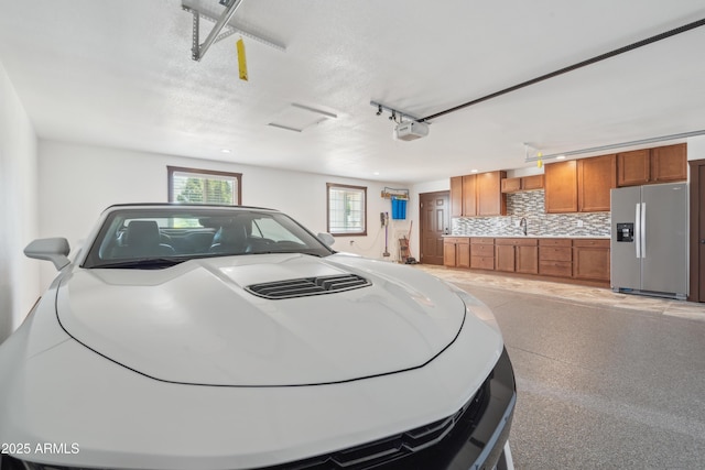 920 N 104th St, Mesa, AZ 85207 - garage featuring stainless steel fridge, a garage door opener, and a sink