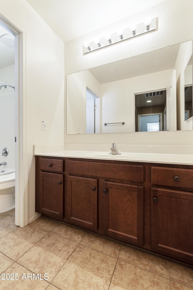 bathroom featuring shower / bathing tub combination, vanity, toilet, and tile patterned floors