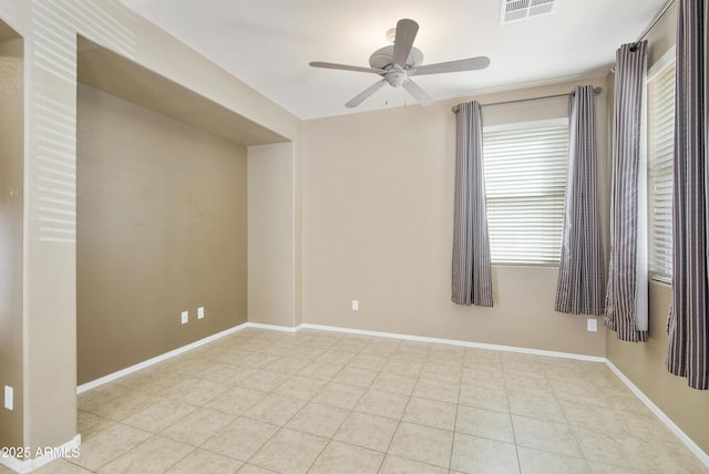 spare room with a ceiling fan, visible vents, baseboards, and light tile patterned flooring