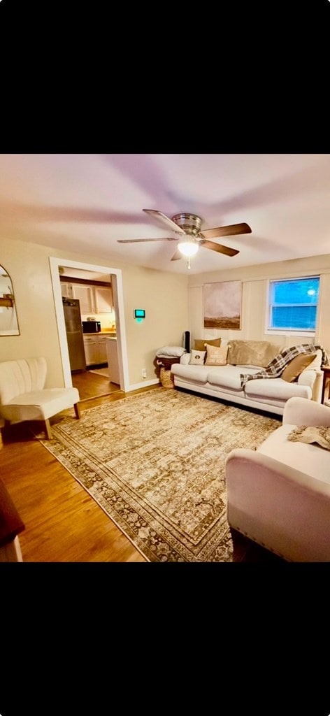 living room with ceiling fan and wood finished floors