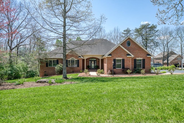 view of front of house with a front lawn, crawl space, and brick siding