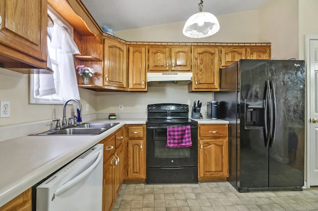 kitchen with brown cabinetry, lofted ceiling, a sink, black appliances, and under cabinet range hood