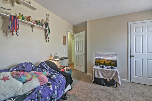 bedroom featuring baseboards, carpet floors, and a textured ceiling