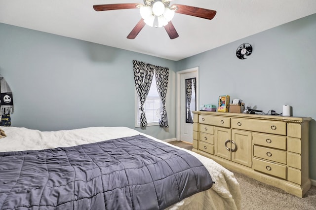 bedroom featuring light colored carpet, a ceiling fan, and baseboards